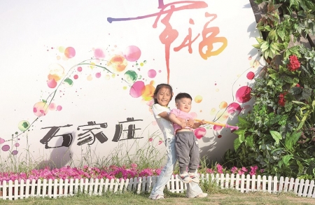 <br>          ■5月18日，两名小朋友在石家庄市正太广场花束景观前玩耍 ■供图/新华社<br><br>        