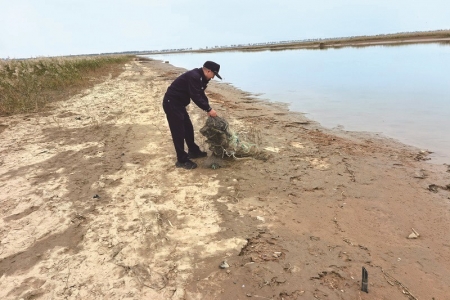 <br>          ■民警在清除湿地上残留的废弃渔网<br><br>        