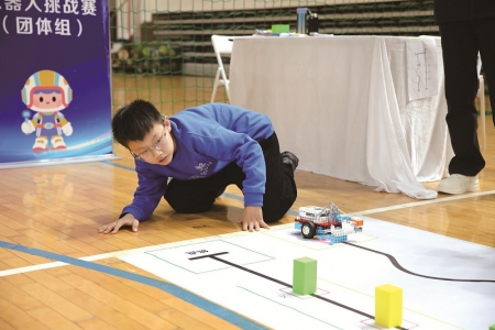 <br>          ■机器人挑战赛团体赛现场，一位选手在赛前仔细检查赛道设施<br><br>        