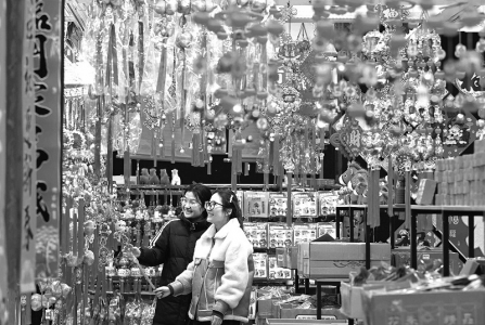 <br>          ■1月25日，两名年轻人在石家庄市义堂年货市场选购春节饰品 ■供图/新华社<br><br>        