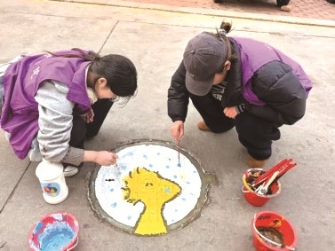<br>          ■志愿者们在井盖上绘制多彩图案<br><br>        